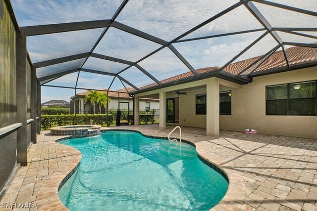 view of pool with glass enclosure, a pool with connected hot tub, and a patio area