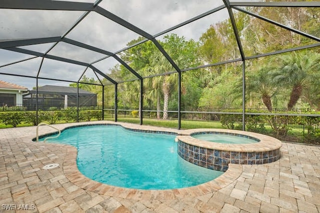 view of pool featuring a pool with connected hot tub, a lanai, a patio, and fence