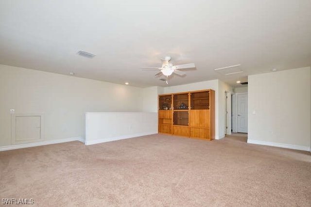 spare room with visible vents, a ceiling fan, light colored carpet, and baseboards