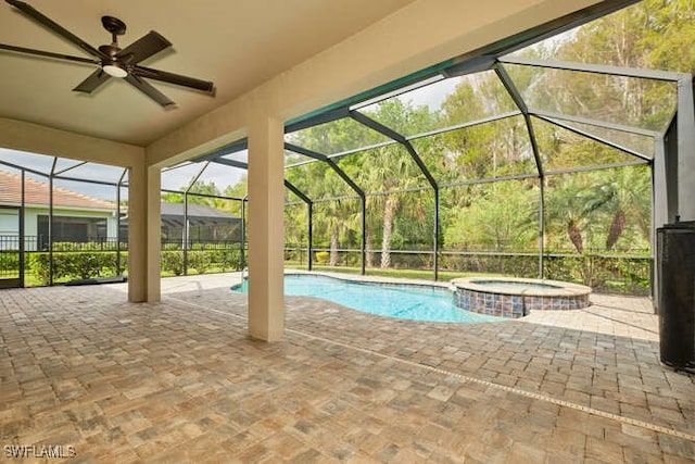 view of pool featuring glass enclosure, a pool with connected hot tub, and a patio area