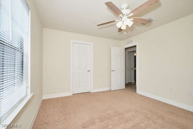 unfurnished bedroom featuring visible vents, ceiling fan, light carpet, and baseboards