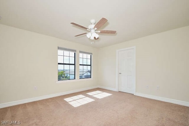 unfurnished room featuring light carpet, ceiling fan, and baseboards