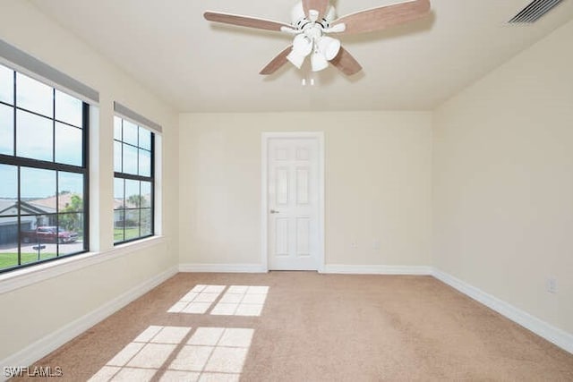 spare room with light carpet, visible vents, and baseboards