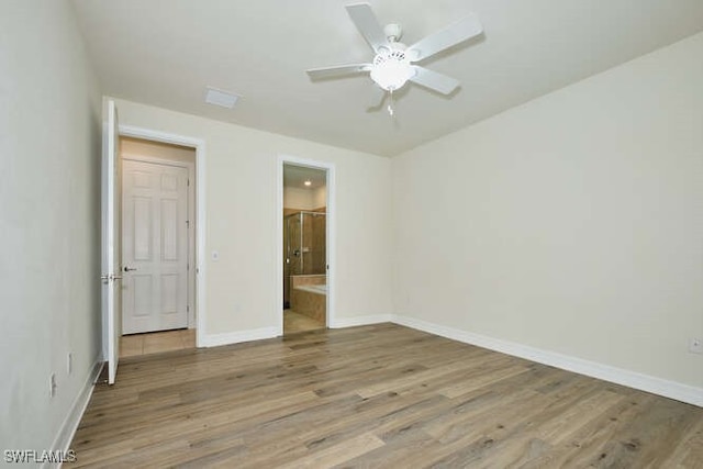 unfurnished bedroom with ensuite bath, baseboards, ceiling fan, and wood finished floors