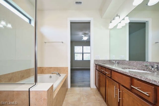 full bath with visible vents, a sink, a garden tub, and double vanity