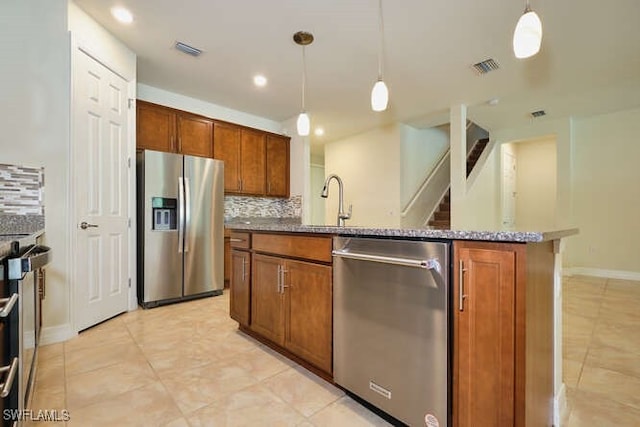 kitchen with hanging light fixtures, visible vents, brown cabinets, and stainless steel appliances