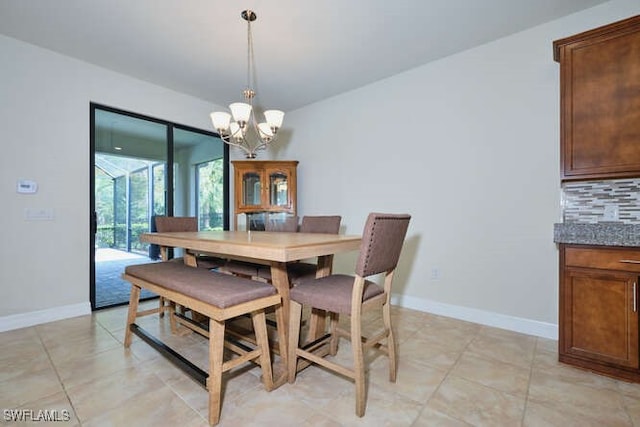dining area featuring a chandelier, light tile patterned floors, and baseboards