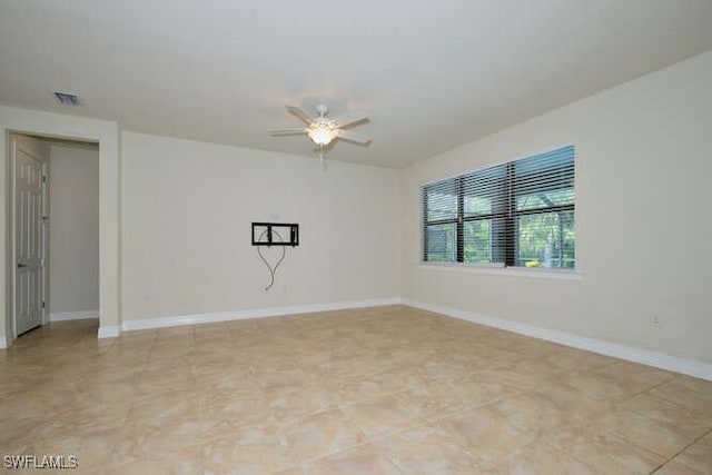 spare room featuring visible vents, baseboards, and a ceiling fan