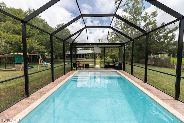 view of pool with a patio area, a playground, glass enclosure, and a lawn