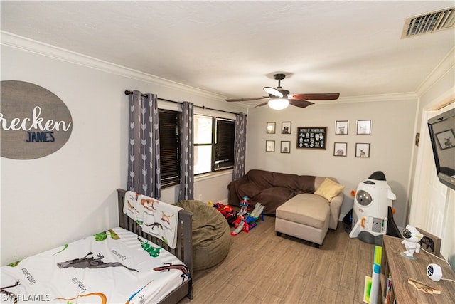 bedroom with ceiling fan, crown molding, and wood-type flooring