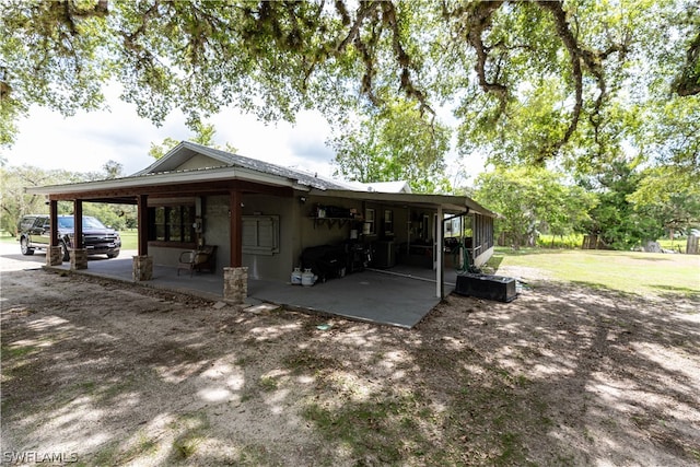 view of side of property featuring a patio area and a lawn