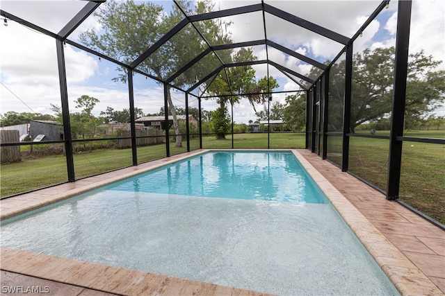 view of pool with a lawn and a lanai