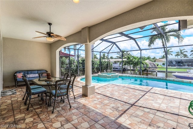 view of swimming pool with glass enclosure, an outdoor hangout area, ceiling fan, an in ground hot tub, and a patio