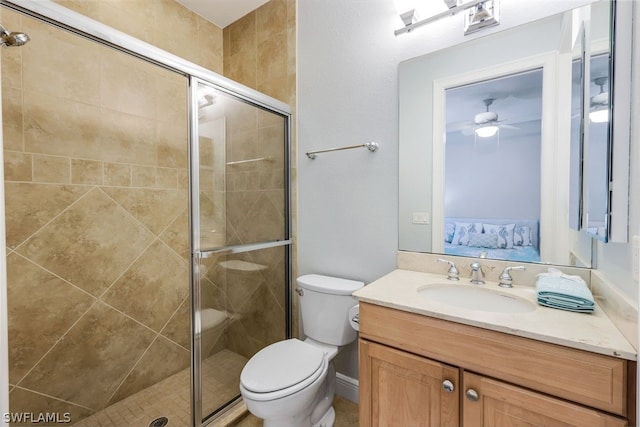 bathroom with ceiling fan, toilet, a shower with shower door, and vanity