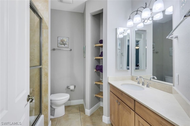 bathroom featuring tile patterned floors, vanity, toilet, and a notable chandelier