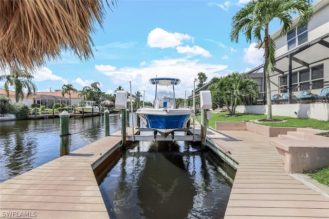 view of dock with a lanai and a water view