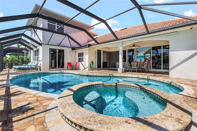 view of pool featuring an in ground hot tub, glass enclosure, ceiling fan, and a patio area