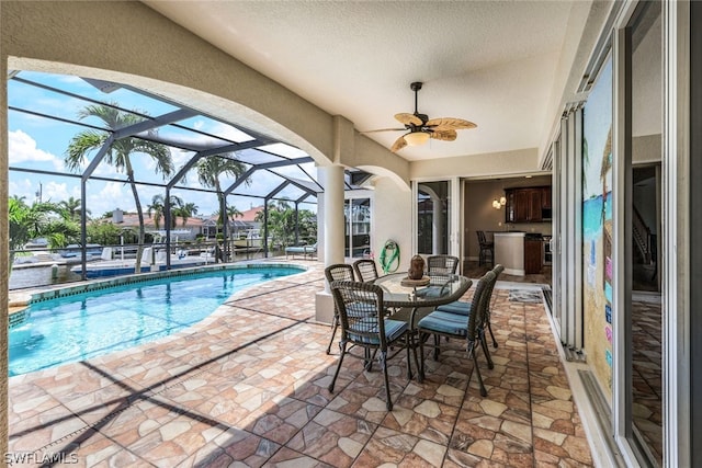 view of swimming pool with a lanai, ceiling fan, area for grilling, and a patio area