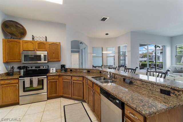 kitchen featuring hanging light fixtures, sink, light tile patterned floors, appliances with stainless steel finishes, and kitchen peninsula