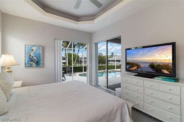 bedroom with ceiling fan, access to outside, and a tray ceiling