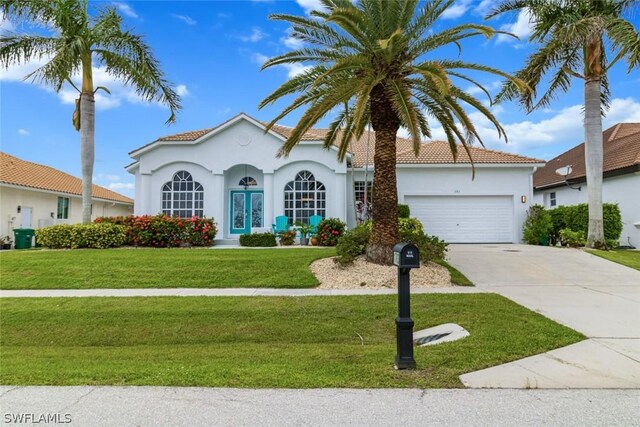 mediterranean / spanish-style home featuring a front yard and a garage