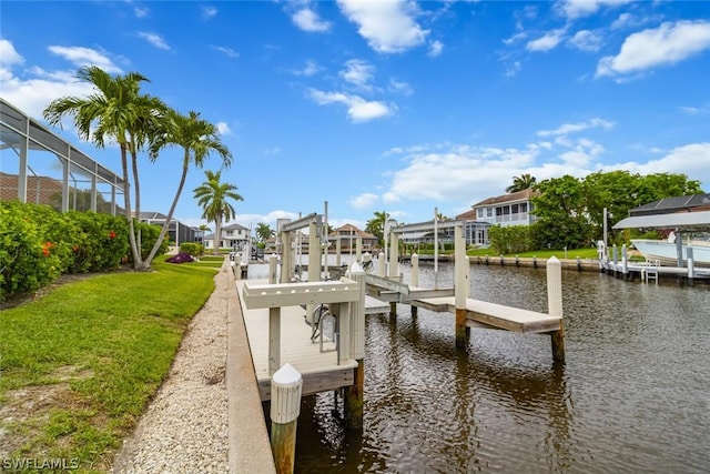 dock area featuring a water view, glass enclosure, and a lawn