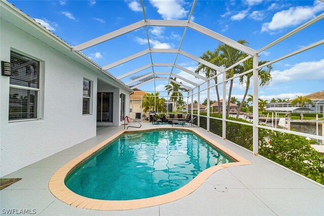 view of swimming pool featuring glass enclosure and a patio