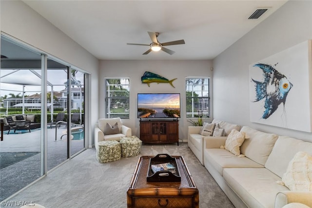 living room with ceiling fan, plenty of natural light, and carpet