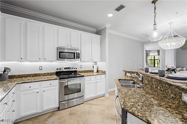 kitchen featuring sink, white cabinets, stainless steel appliances, and decorative light fixtures