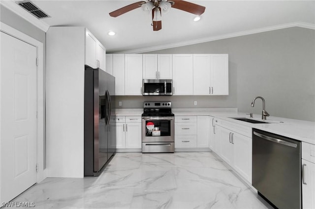 kitchen with lofted ceiling, crown molding, sink, white cabinetry, and stainless steel appliances