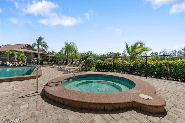 view of pool featuring a patio area and a community hot tub