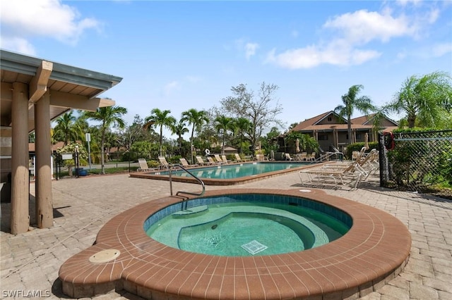 view of swimming pool featuring a community hot tub and a patio