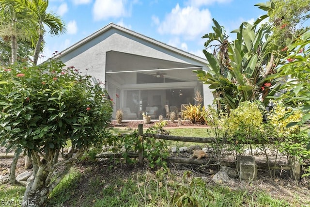 rear view of house featuring a sunroom and ceiling fan