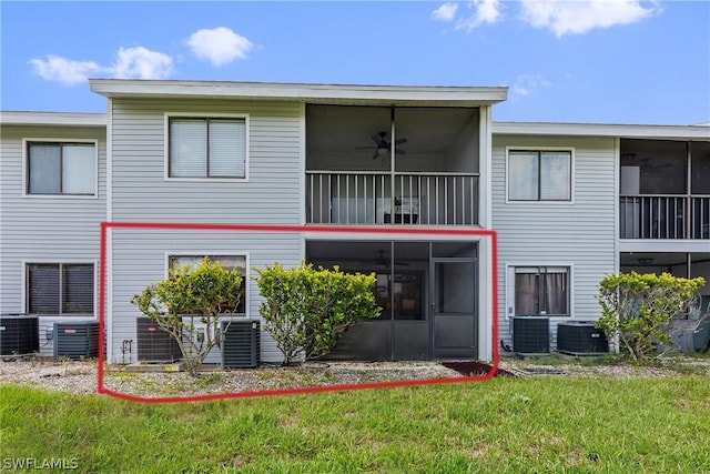 back of property with central air condition unit, a sunroom, a ceiling fan, and a lawn