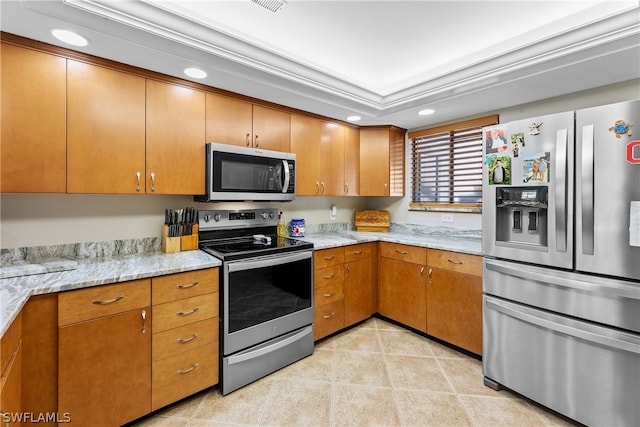 kitchen featuring light stone counters, stainless steel appliances, and crown molding