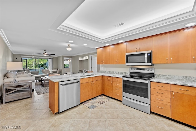 kitchen featuring ceiling fan, light tile patterned flooring, kitchen peninsula, crown molding, and appliances with stainless steel finishes