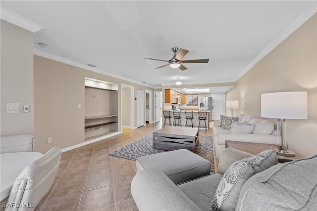 tiled living room with ornamental molding and ceiling fan