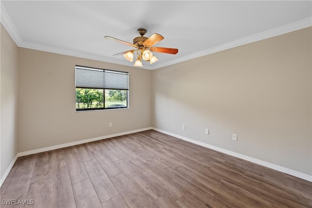 empty room featuring baseboards, wood finished floors, ceiling fan, and crown molding