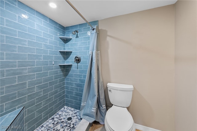 bathroom with tile patterned floors, toilet, and curtained shower