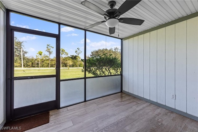 unfurnished sunroom featuring plenty of natural light and a ceiling fan