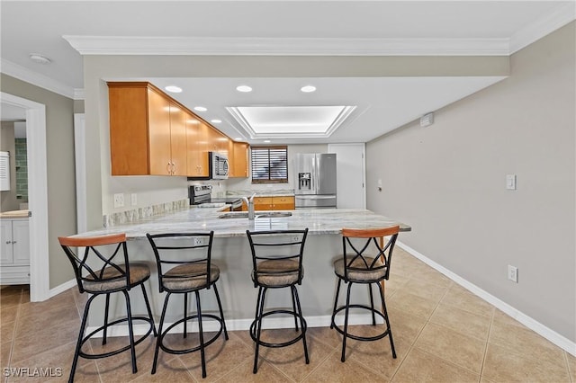 kitchen featuring crown molding, a sink, a peninsula, stainless steel appliances, and baseboards