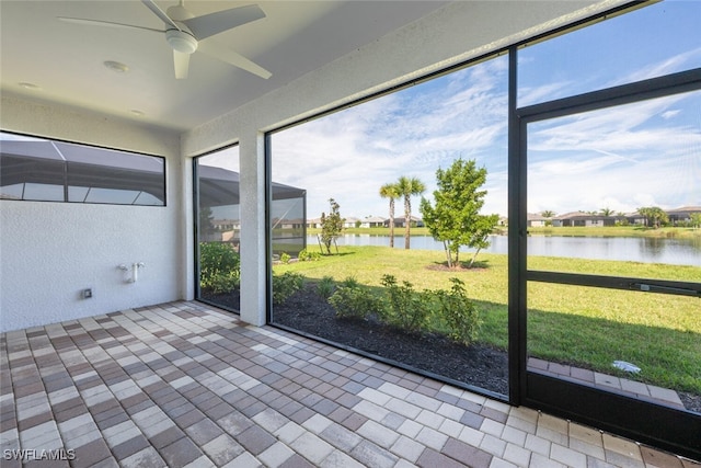 unfurnished sunroom featuring a water view and ceiling fan