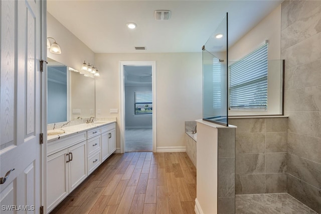 bathroom with a tile shower and vanity