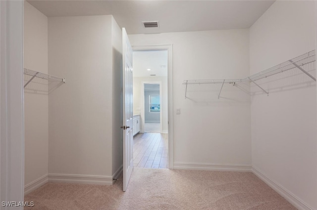 spacious closet featuring light carpet