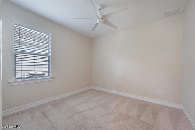 spare room featuring light carpet and ceiling fan