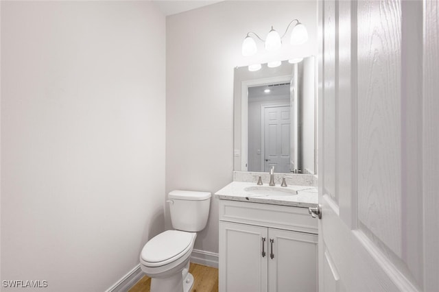 bathroom featuring hardwood / wood-style floors, vanity, and toilet