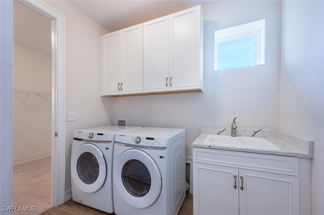 laundry room featuring cabinets, sink, light colored carpet, and washer and dryer