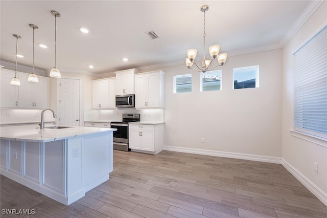 kitchen featuring white cabinets, decorative light fixtures, sink, and appliances with stainless steel finishes