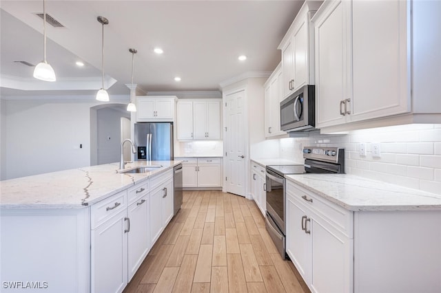 kitchen featuring appliances with stainless steel finishes, decorative light fixtures, and white cabinetry