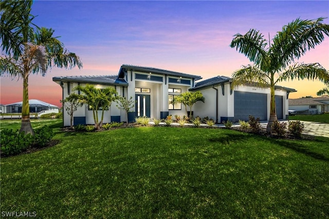 view of front of property featuring a yard and a garage